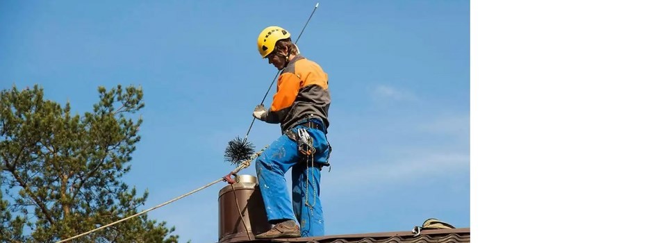 spazzacamino sul tetto con imbracatura e casco.jpg